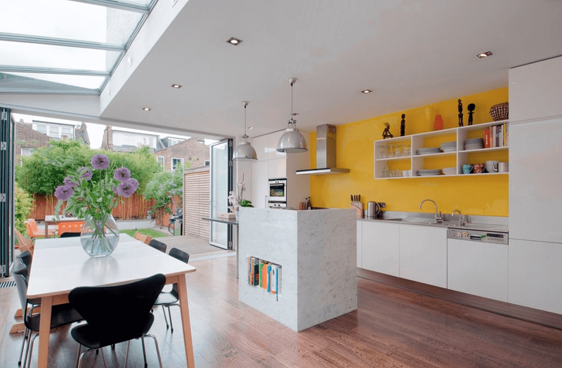 picture of a modern kitchen with a yellow wall and white cabinets