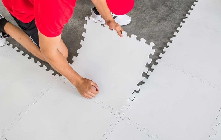 man putting hockey tiles on the floor